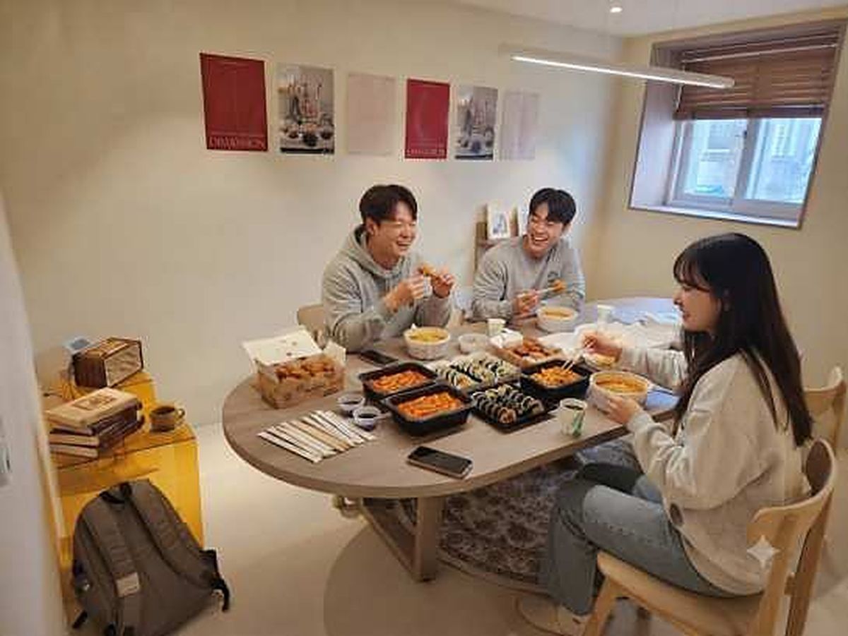 사 온 음식을 테이블에 펼쳐 놓고 함께 먹는 손님들